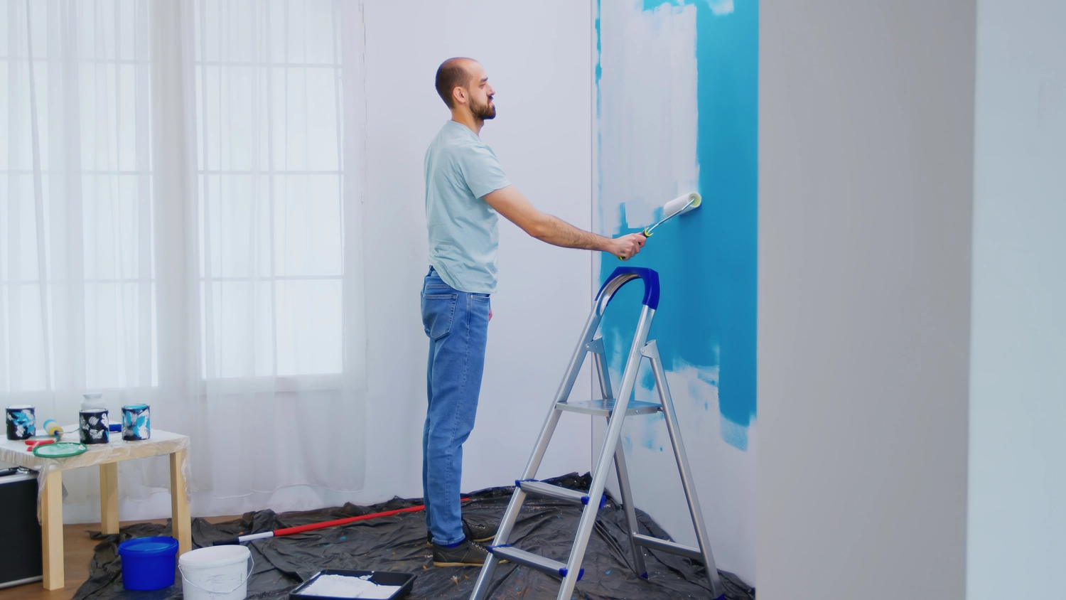 Malerbetrieb Renner - Arbeiter beim Streichen der Hauswand